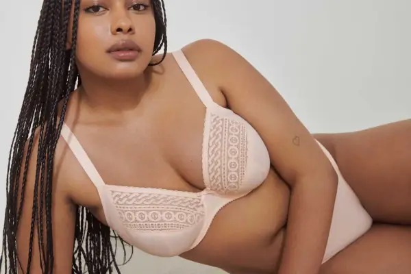 Modello con trecce indossa un reggiseno color pesca con pizzo. La taglia 4b reggiseno a cosa corrisponde?
