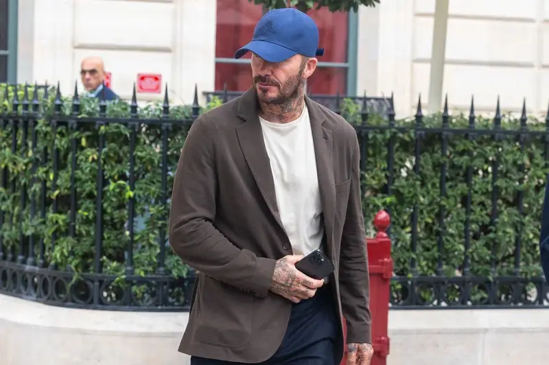 Uomo con cappellino blu e giacca marrone, dimostra che blu e marrone stanno bene insieme.